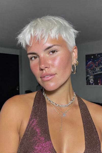 Eine Frau mit einem modernen, kurz geschnittenen weißen Pixie-Cut mit fransigem Pony.
